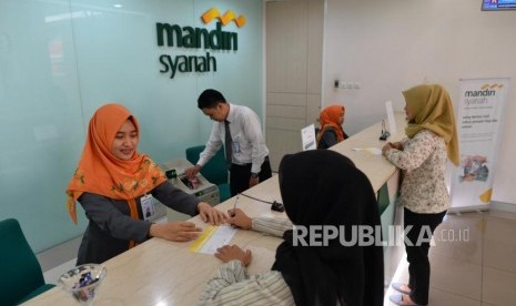 Teller melayani nasabah di Bank Syariah Mandiri (Mandiri Syariah), (ilustrasi). Bank Syariah Mandiri (Mandiri Syariah) menyambut positif wacana merger bank-bank syariah anak usaha BUMN yang dilontarkan oleh Menteri BUMN, Erick Thohir. 