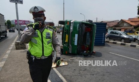 Petugas mengatur lalu lintas saat terjadi kecelakaan antara truk kontainer dan angkutan umum. (ilustrasi)