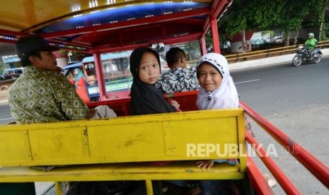 Sejumlah penumpang menaiki kendaraan odong-odong.