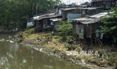 Seorang warga membersihkan sampah di dekat pemukiman kumuh di kawasan Manggarai, Jakarta, Selasa (5/11). Center of Reform on Economics (CORE) Indonesia memperkirakan, jumlah penduduk di bawah garis kemiskinan berpotensi bertambah 5,1 juta sampai 12,3 juta orang pada kuartal kedua 2020. 