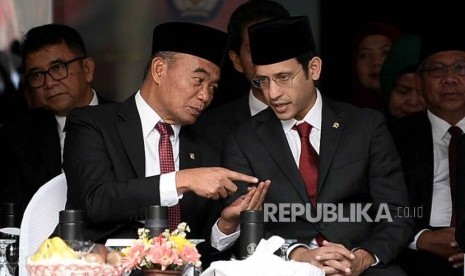 Menteri Pendidikan dan Kebudayaan Nadiem Makarim berbincang dengan Menko PMK Muhadjir Effendy saat menghadiri upacara peringatan Hari Guru Nasional 2019 di halaman Kementrian Pendidikan dan Kebudayaan, Senayan, Jakarta, Senin (25/11).