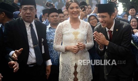 Menteri Pendidikan dan Kebudayaan Nadiem Makarim berserta istri memberi salam saat menghadiri upacara peringatan Hari Guru Nasional 2019 di halaman Kementrian Pendidikan dan Kebudayaan, Senayan, Jakarta, Senin (25/11).