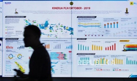 P2IS PLN. Seorang pengunjung melintasi layar informasi di Pusat Pengelola Informasi dan Solusi (P2IS) tahap pertama di Kantor Pusat PLN, Jakarta, Rabu (27/11).