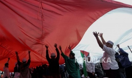 Massa yang tergabung dalam Alumni 212 mengibarkan bendera meeah putih saat aksi reuni 212 di lapangan Monumen Nasional, Jakarta, Senin (2/12).