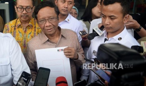 Menko Polhukam Mahfud MD (kanan) menjawab pertanyaan wartawan seusai menyerahkan Laporan Harta Kekayaan Penyelenggara Negara (LHKPN) di gedung KPK, Jakarta, Senin (2/12).