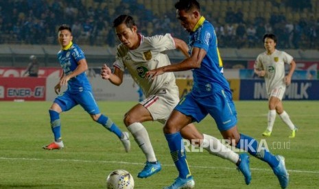 Pesepakbola Persib Bandung Frets Butuan (kanan) berebut bola dengan pesepakbola Persela Lamongan Ahmad Birrul (kiri) saat laga lanjutan Liga 1 di Stadion Si Jalak Harupat, Kabupaten, Bandung, Jawa Barat, Selasa (3/12/2019).