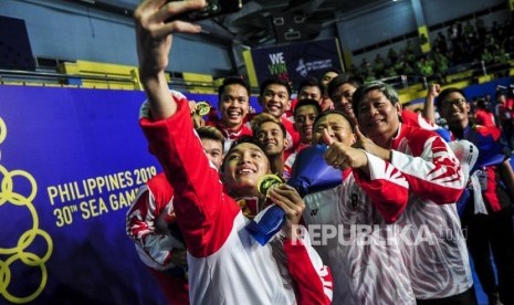 Sejumlah pebulutangkis Indonesia bersama ofisial berswafoto sambil menunjukan medali emas usai memenangkan pertandingan melawan pebulutangkis Malaysia pada final bulu tangkis kelas kategori beregu putra di Muntinlupa Sports Complex, Manila, Filipina, Rabu (4/12).