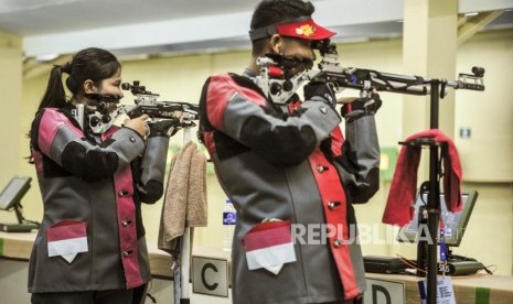 Atlet menembak Indonesia Vidya Rafika Rahmatan Toyyiba (kiri) dan Fathur Gustafian (kanan) membidik target pada babak final cabang olahraga menembak kategori 10 meter air rifle mixed team di Philipine Marine Shooting Range Total, Filipina, Kamis (5/12).