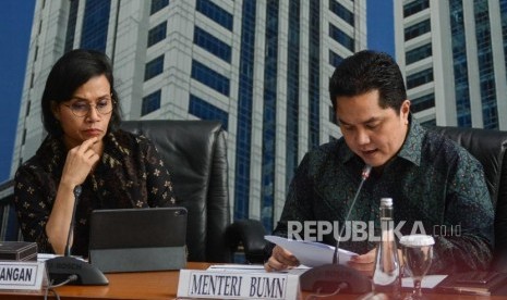 Menteri Badan Usaha Milik Negara (BUMN) Erick Thohir (kanan) bersma Menteri Keuangan Sri Mulyani (kiri) saat konferensi pers di Gedung Kementerian Keuangan, Jakarta, Kamis (5/12).