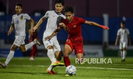 Gelandang Timnas Indonesia Egy Maulana Vikri (kanan) berebut bola dengan bek Timnas Laos Kittisak Phomvongsa pada pertandingan Grup B Sea Games 2019 di City Of Imus Grandstanf, Filipina, Kamis (5/12).