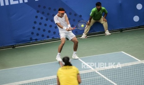 Petenis Indonesia Christopher Rungkat memukul bola saat melawan petenis Thailand Sanchai Ratiwatana dan Tamarine Tanasugarn pada pertandingan final tenis kategori ganda campur di RMSC Tennis Court, Manila, Filipina, Sabtu (7/12).