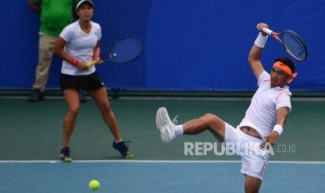 Petenis ganda campuran Indonesia Christopher Rungkat (kanan) dan Aldila Sutjiadi mengembalikan bola.