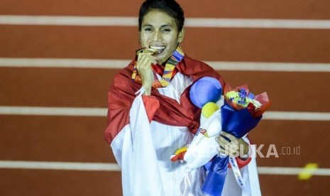 Atlet lompat jauh Indonesia Maria Natalia Londa menggigit medali emas usai pertandingan lompat jauh putri Sea Games 2019 di Stadion Atletik New Clark, Filipina, Ahad (8/12).