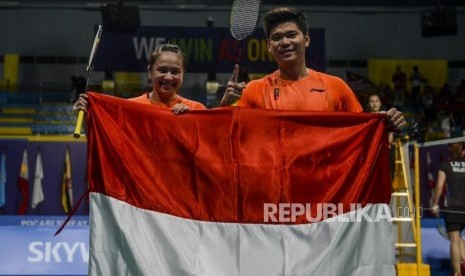 Pebulutangkis Indonesia Praveen Jordan dan Melati Daeva Oktavianti berpose dengan bendera merah putih usai memena pertandingan melawan pebulutangkis Malaysia Goh Soon Huat dan Lai Shevon Jemie pada final bulu tangkis kategori ganda campuran di Muntinlupa Sports Complex, Manila, Filipina, Senin (9/12).