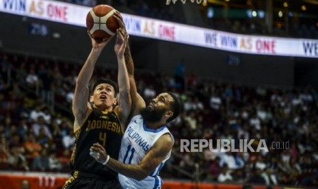 Pebasket Indonesia Abraham Damar Grahita (kiri) mencoba melempar bola dibayangi oleh pebasket Filipina Stanley Pringle saat pertandingan babak semi final basket di SM Mall of Asia Arena, Manila, Filipina, Senin (9/12).