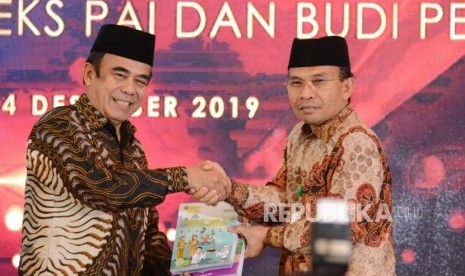 Menteri Agama Fahrul Razi menyerahkan buku PAI sebagai simbolis kepada perwakilan Kementerian Pendidikan dan Kebudayaan Kahmim (kanan) membuka acara Sarasehan Bulan Bakti Pendidikan Agama Islam di Hotel Santika, Bekasi, Jawa Barat, Sabtu (14/12).