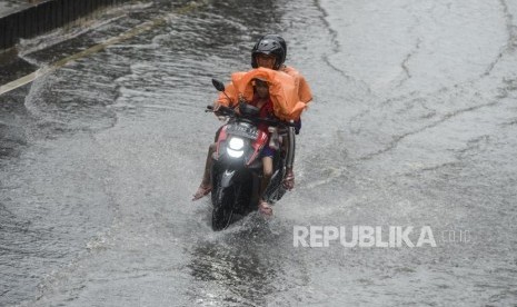 Pengendara motor menerobos genangan air. Foto (ILustrasi)