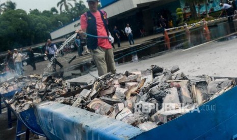 Sejumlah petugas menyiram barang bukti rokok ilegal yang telah dibakar di Kantor Bea Cukai, Rawamangun, Jakarta, Kamis, (19/12).