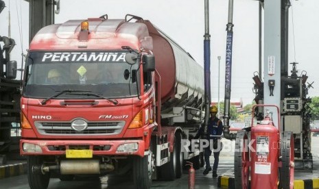 Seorang petugas mobil tangki bersiap mengisi BBM ke mobil tangki di Terminal BBM Plumpang, Jakarta, Senin (23/12).