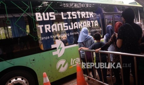 Warga bersiap menaiki bus listrik di Kawasan Monas, Jakarta, Kamis (26/12).