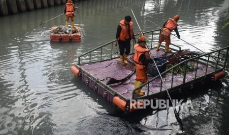 Petugas UPK Badan Air Dinas Lingkungan Hidup DKI Jakarta membersihkan sampah di Kali Cideng, Jakarta, Senin (30/12).