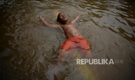 Sejumlah anak bermain saat banjir di Gang Hj Agus, Jatipadang, Jakarta, Rabu (1/1). Kawasan Pejaten dekat Jatipadang juga terserang banjir di awal tahun baru.