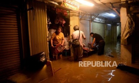 Sejumlah pedagang mengamankan barang dagangannya ketika banjir merendam lantai dasar Pasar Jatinegera, Jakarta, Kamis (2/1).