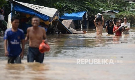 YBM BRI menyalurkan bantuan untuk warga korban banjir di Jakarta. Foto warga melintasi banjir di Jalan Jatinegara Barat, Kampung Pulo, Jakarta, (ilustrasi).