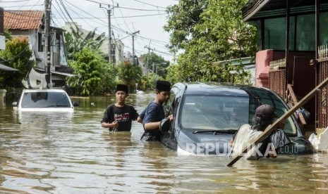 Sejumlah warga melihat kondisi mobil yang terendam saat terjadi banjir di Perumahan Ciledug Indah, Tangerang, Banten Kamis (2/1).