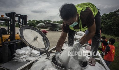 Petugas TMC memasukan garam ke tabung penampung garam atau consul dalam pelaksanaan Operasi Teknologi Modifikasi Cuaca (TMC) yang menggunakan pesawat CN 295 di Skadron Udara 2 Lanud Halim Perdanakusuma, Jakarta, Jumat (3/1/2020).