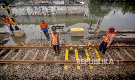 Pekerja memperbaiki rel pascabanjir di kawasan Stasiun Rawa Buaya, Jakarta, Jumat (3/1/2020). PT KAI (Persero) memastikan jalur rel kereta api aman dilalui mengingat pemeriksaan rutin terus dilakukan setiap saat dan setiap hari ketika curah hujan tinggi belakangan ini. 