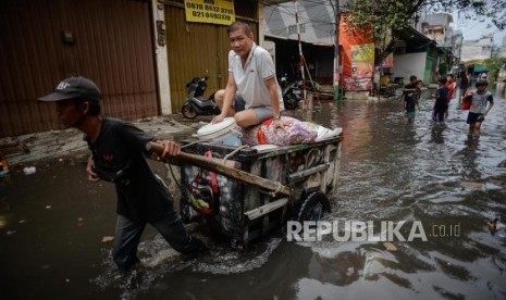 Sejumlah warga melawati genangan air banjir di Jalan Teluk Gong, Penjaringan, Jakarta Utara, Sabtu (4/11).