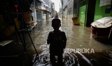 Sejumlah warga melawati genangan air banjir di Jalan Teluk Gong, Penjaringan, Jakarta Utara, Sabtu (4/11).