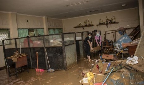 Dua murid SMA Negeri 8 Jakarta membersihkan salah satu ruang belajar di sekolahnya pascabanjir di Bukit Duri, Tebet, Jakarta, Sabtu (4/1/2020).