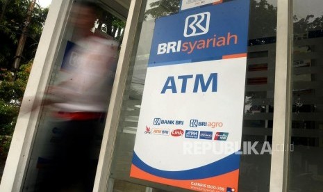 Nasabah berjalan usai melakukan transaksi melalui ATM Bank BRI Syariah, Jakarta, Ahad (5/1).