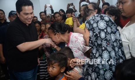 Menteri BUMN Erick Thohir bersalaman dengan para pengungsi korban banjir di Posko pengungsian GOR Cengkareng,Jakarta, Ahad (5/1).