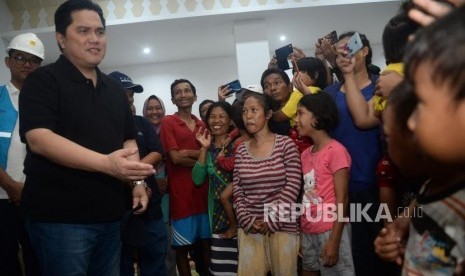 Menteri BUMN Erick Thohir bercengkrama dengan para pengungsi korban banjir di posko pengungsian GOR Cengkareng,Jakarta, Ahad (5/1).