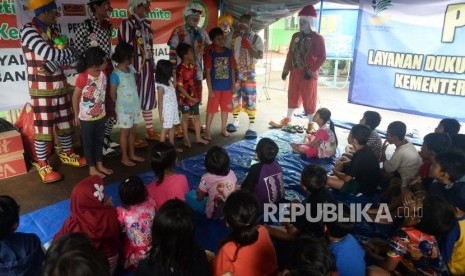 Sejumlah Badut dari Aku Badut Indonesia menghibur anak korban bencana banjir di posko pengungsian Masjid Jami Al Umariyah,Komplek IKPN Bintaro, Jakarta, Ahad (5/1).