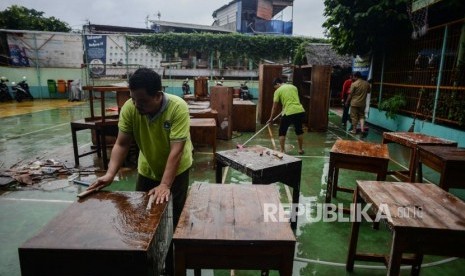 Sejumlah guru membersihkan sarana belajar saat kerja bakti di SMP Negeri 46 Jakarta, Jalan Rukun, Pasar Minggu, Senin (6/1).