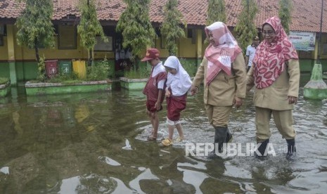 Sejumlah guru dan murid SDN 05 beraktivitas saat banjir di daerah Pondok Ungu, Kabupaten Bekasi, Jawa Barat, Senin (6/1/2020).