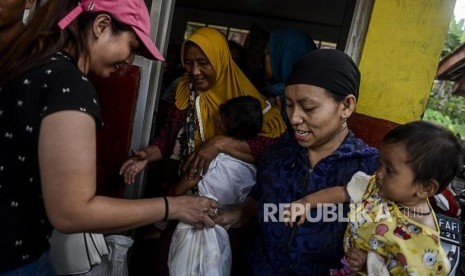 Sejumlah warga menerima bantuan sembako di Desa Harkatjaya, Sukajaya, Bogor, Jawa Barat, Senin (6/1).