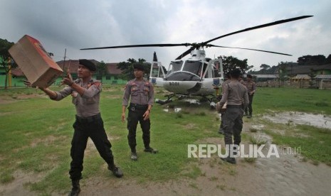 Anggota Polairud Polda Banten secara estafet mengangkut logistik kedalam helikopter untuk disalurkan melalui udara kepada para korban banjir yang terisolir di halaman Ponpes Latansa Rangkasbitung, Lebak, Banten, Senin (6/1/2020).