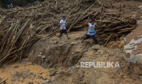 Sejumlah warga melintasi longsor di Kampung Banar, Sukajaya, Bogor, Jawa Barat, Selasa (7/1).