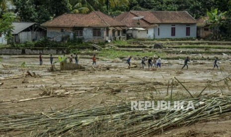 Sejumlah warga melintasi lumpur akibat longsor di Kampung Banar, Sukajaya, Bogor, Jawa Barat, Selasa (7/1).