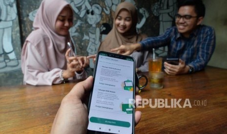 Sejumlah anak muda tengah membuka rekening Mandiri Syariah melalui aplikasi Mandiri Syariah Mobile di salah satu kafe di Jakarta, Rabu (8/1).