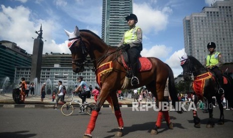 Polisi berkuda berpatroli saat pelaksanaan Hari Bebas Kendaraan Bermotor (HBKB) di kawasan Bundaran HI, Jakarta, Ahad (12/1).