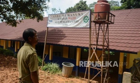 Guru Sekolah Dasar Negeri 1 Lebaksitu meliihat kondisi sekolah terdampak longsor di Kampung Gunung Julang, Desa Lebaksitu, Kecamatan Lebak Gedong, Banten, Senin (13/1).