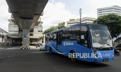 Bus Transjakarta melintas di dekat Stasiun MRT ASEAN di Jakarta, Selasa (14/1).