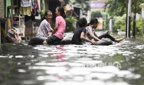 Anak-anak bermain saat terjadi banjir di daerah Kelurahan Gunung, Kebayoran Baru, Jakarta, Sabtu (18/1/2020).