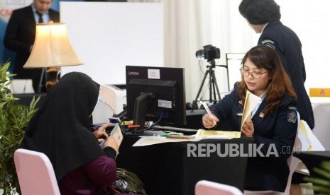 Petugas Imigrasi membatu warga membuat paspor pada Festival Keimigrasian 2020 di Gedung Pusat BRI, Jakarta, Sabtu (18/1).